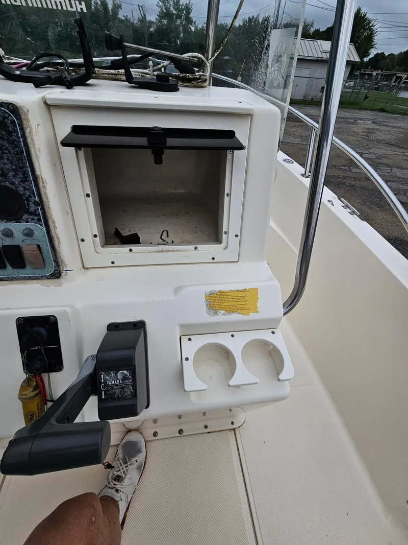 Slide: The Image of Center console of a 2005 Key West 2020CC boat with storage compartment and controls. - 9