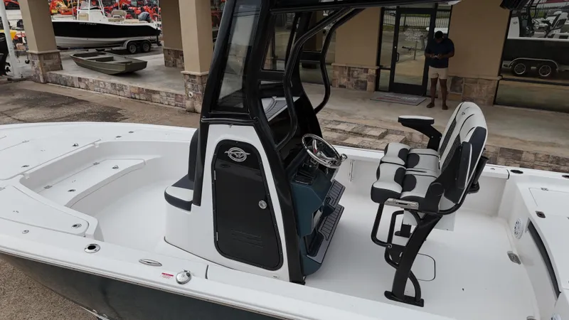 Slide: The Image of 2023 Tidewater 2410BM boat with sleek design and modern seating, displayed outdoors. - 20