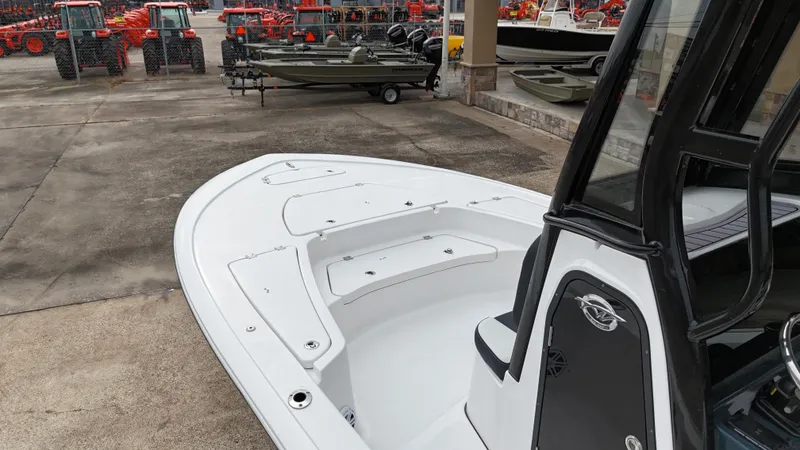 Slide: The Image of 2023 Tidewater 2410BM boat displayed in a dealership lot with tractors in the background. - 22