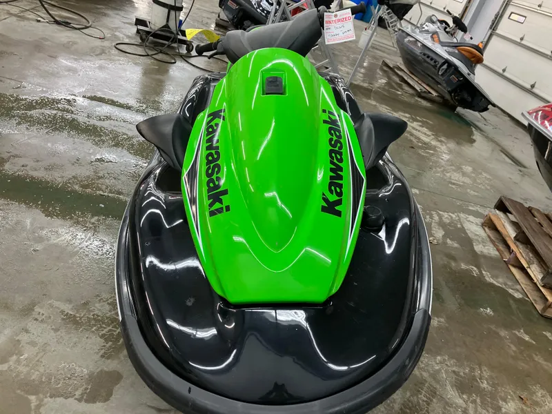 Slide: The Image of 2015 Kawasaki STX15F jet ski in a garage, vibrant green and black design. - 4