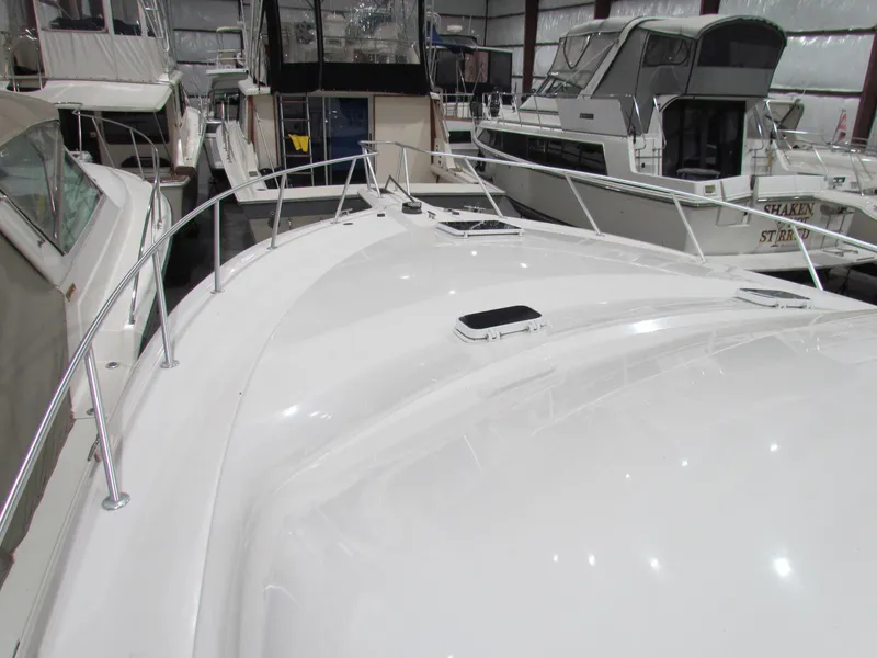 Slide: The Image of 2000 Ocean Yachts 48 Sun Sport in marina, sleek white deck, surrounded by other boats. - 12