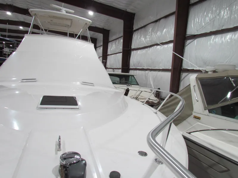 Slide: The Image of Ocean Yachts 48 Sun Sport 2000 model in storage, showcasing sleek white deck design. - 15
