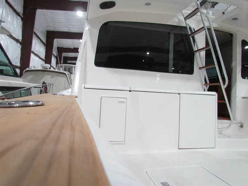 Slide: The Image of 2000 Ocean Yachts 48 Sun Sport in storage, showcasing sleek white exterior and ladder. - 29