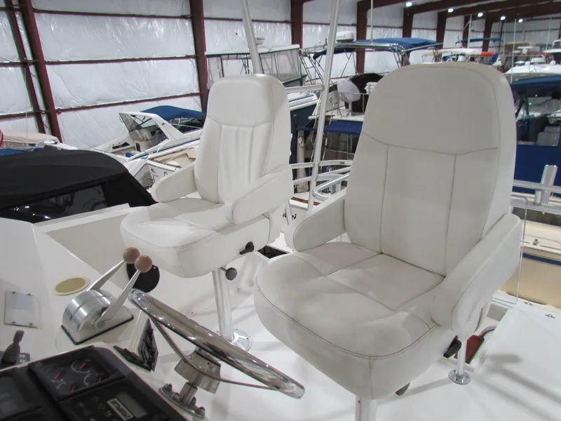 Slide: The Image of Interior helm of 2000 Ocean Yachts 48 Sun Sport with white captain chairs. - 48