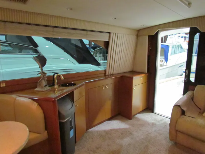 Slide: The Image of Interior of 2000 Ocean Yachts 48 Sun Sport, featuring elegant wood cabinetry and plush seating. - 52