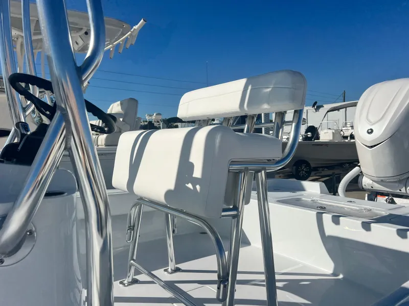 Slide: The Image of 2025 Contender 23 Bay boat interior with white seating and chrome details. - 4