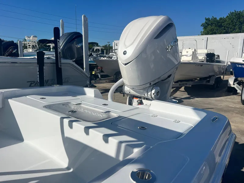 Slide: The Image of 2025 Contender 23 Bay boat with powerful outboard motor in a marina setting. - 7