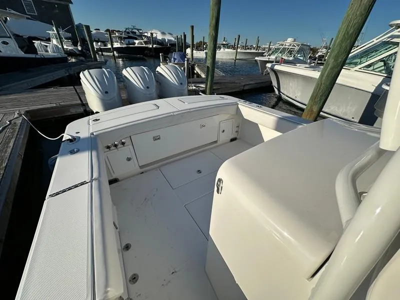 Slide: The Image of 2023 Regulator 34 boat docked, featuring spacious deck and triple outboard engines. - 23