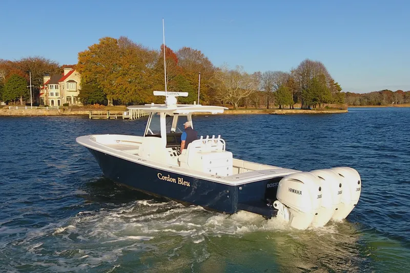 Slide: The Image of 2023 Regulator 34 boat cruising on a scenic lake with autumn trees. - 5