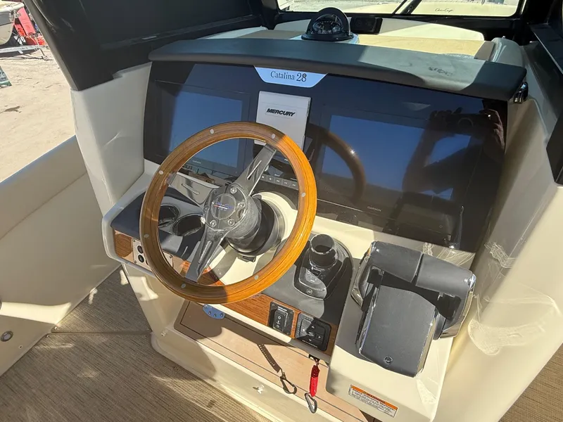 Slide: The Image of 2025 Chris-Craft Catalina 28 helm with wooden steering wheel and modern controls. - 13