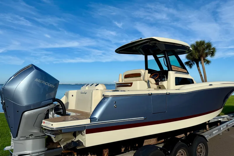 Slide: The Image of 2025 Chris-Craft Catalina 28 boat with Mercury engine on trailer, under clear blue sky. - 5