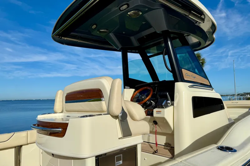 Slide: The Image of 2025 Chris-Craft Catalina 28 boat interior with luxurious seating and steering wheel, docked by the water. - 6