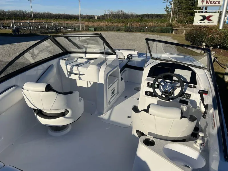 Slide: The Image of 2025 Stingray 201DC boat interior with white seating and modern dashboard controls. - 10