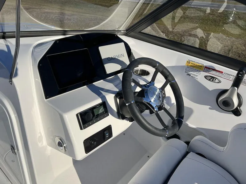 Slide: The Image of 2025 Stingray 201DC boat dashboard with steering wheel, Garmin display, and control panel. - 11