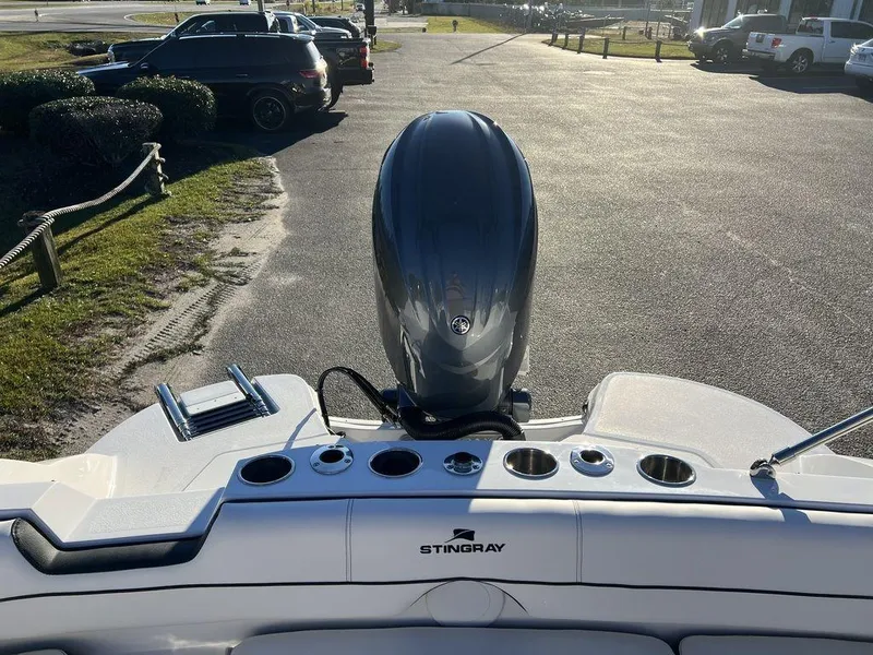 Slide: The Image of 2025 Stingray 201DC boat with outboard motor, parked on a sunny day. - 12