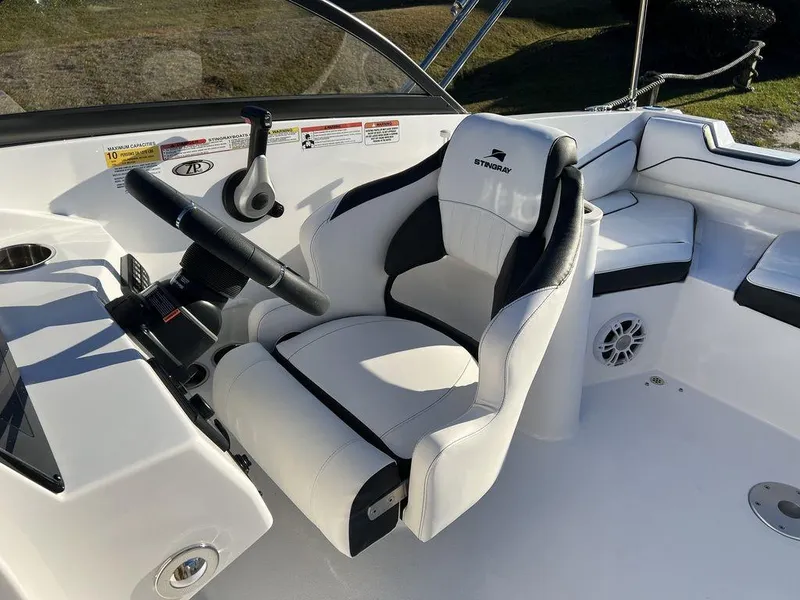 Slide: The Image of 2025 Stingray 201DC boat interior with white captain's chair and steering wheel. - 16