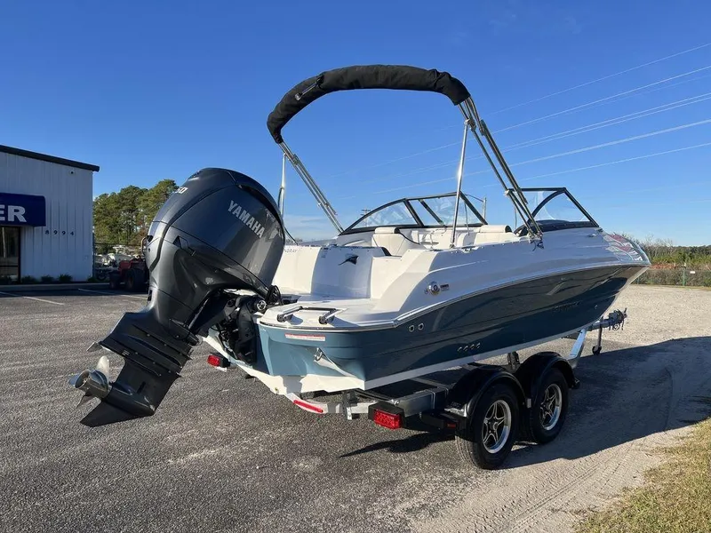 Slide: The Image of 2025 Stingray 201DC boat with Yamaha outboard motor on a trailer, parked outdoors. - 8