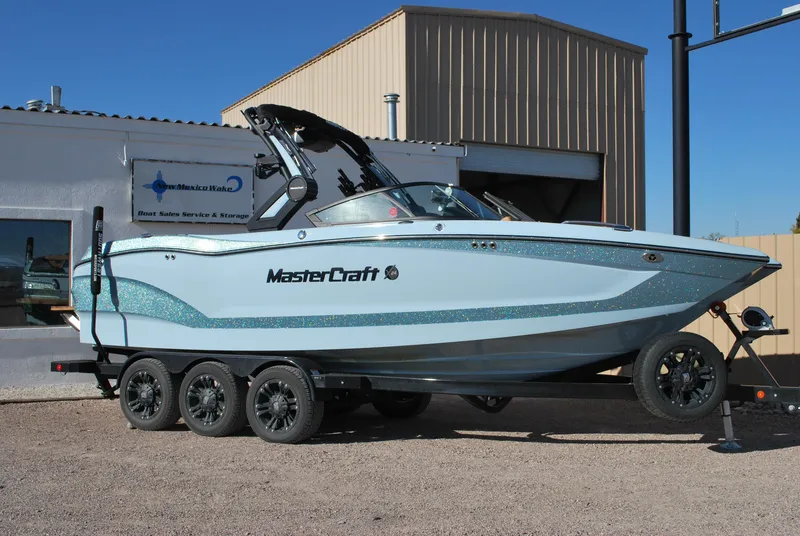 The Image of 2022 MasterCraft X24 boat on trailer outside a building. - 0