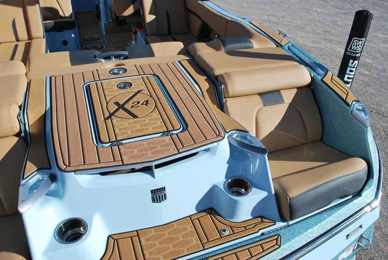 Slide: The Image of 2022 MasterCraft X24 boat interior with tan seating and wood accents. - 15