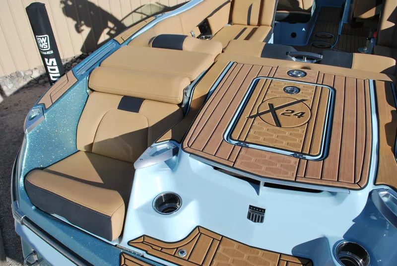 Slide: The Image of 2022 MasterCraft X24 boat interior with tan seating and wood accents. - 16
