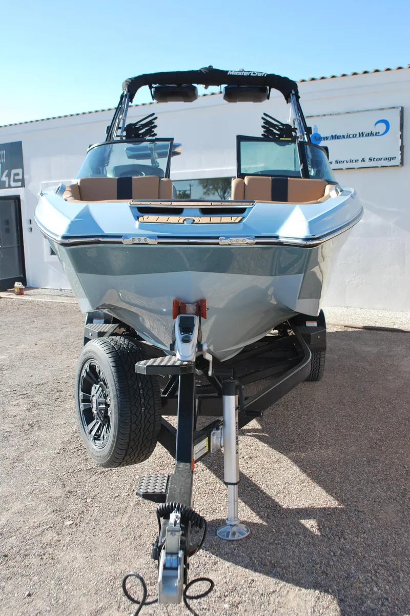 Slide: The Image of 2022 MasterCraft X24 boat on trailer, front view, parked outdoors. - 3