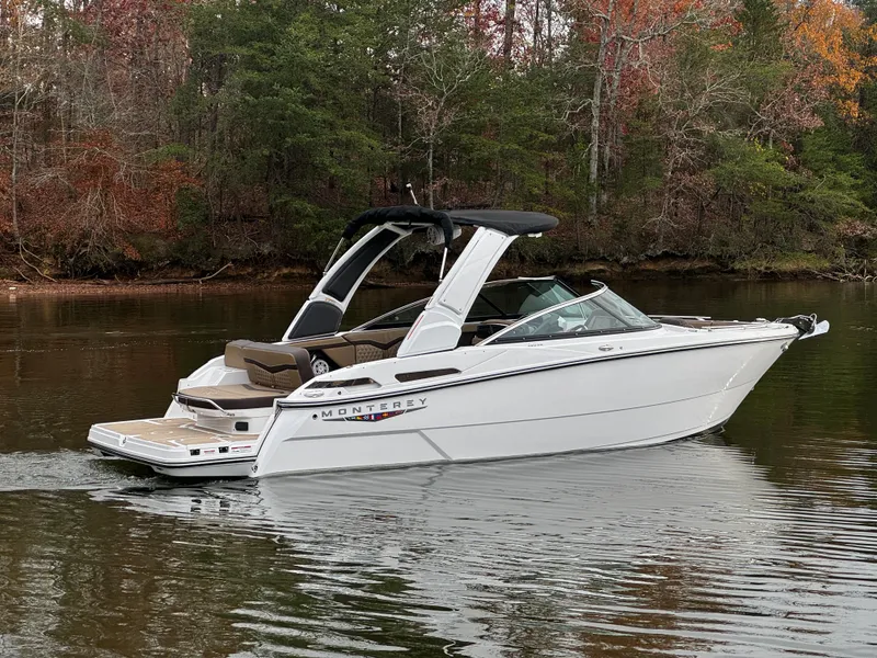 Slide: The Image of 2025 Monterey 258SS boat on a calm lake with autumn trees in the background. - 2