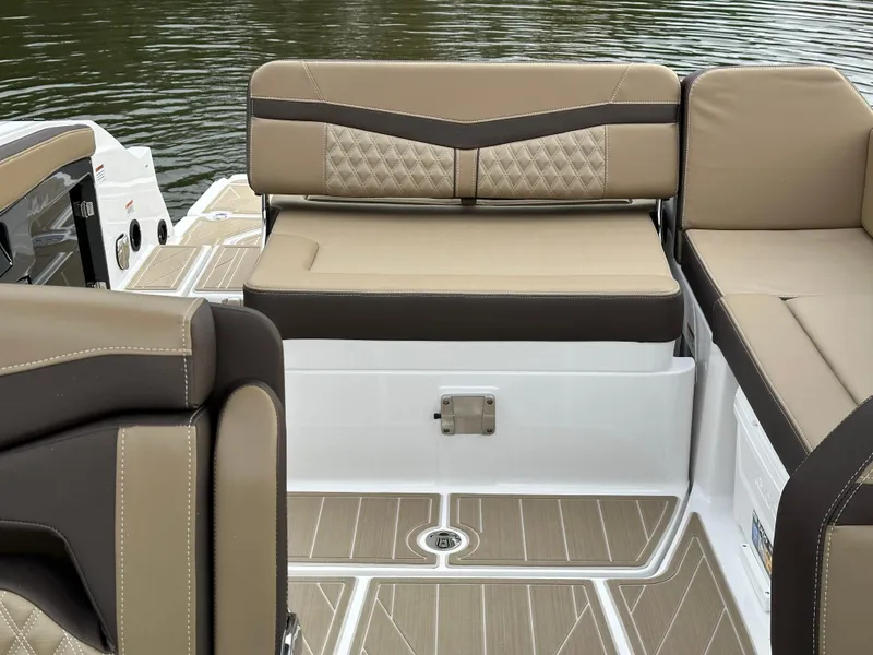 Slide: The Image of 2025 Monterey 258SS boat interior with beige and brown seating, near water. - 21