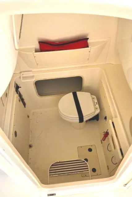 Slide: The Image of 2016 Boston Whaler 320 Outrage Cuddy Cabin interior with compact marine toilet. - 11