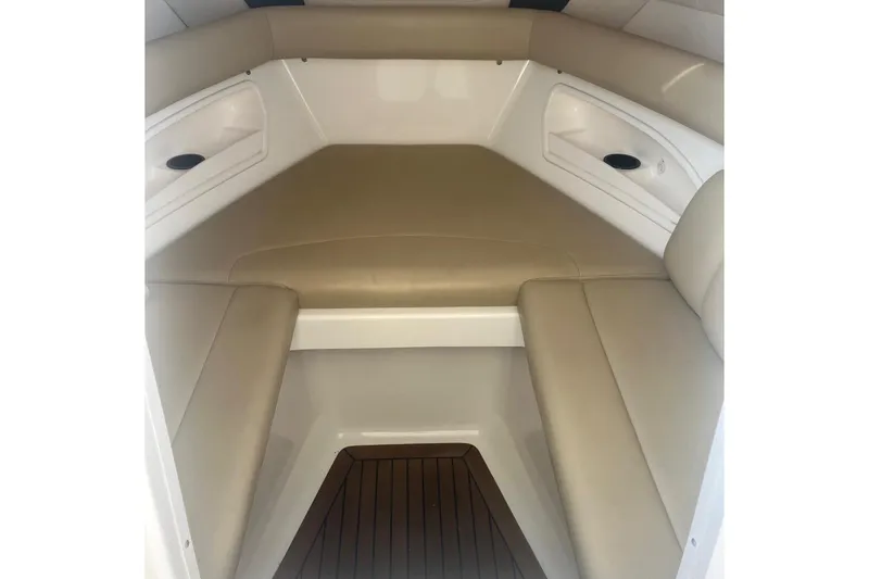 Slide: The Image of 2008 Boston Whaler 320 Outrage Cuddy Cabin interior with beige seating and wood flooring. - 14