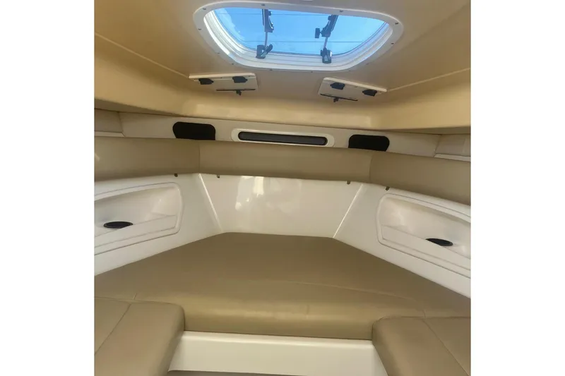 Slide: The Image of 2008 Boston Whaler 320 Outrage Cuddy Cabin interior with beige seating and overhead hatch. - 15