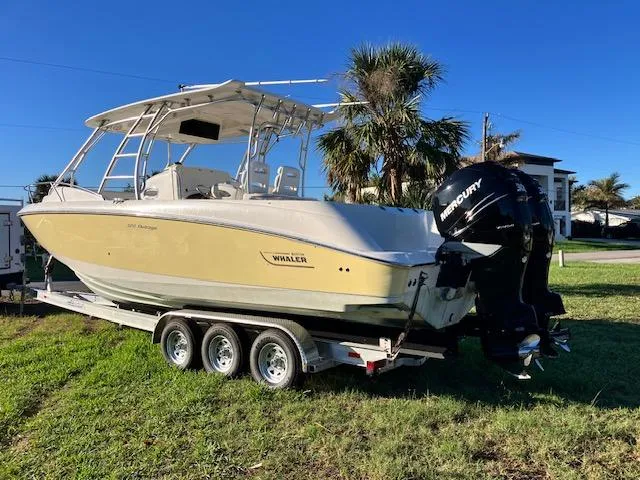 Slide: The Image of 2016 Boston Whaler 320 Outrage Cuddy Cabin on trailer, parked on grass. - 2