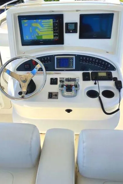 Slide: The Image of 2016 Boston Whaler 320 Outrage Cuddy Cabin helm with navigation screens and controls. - 6
