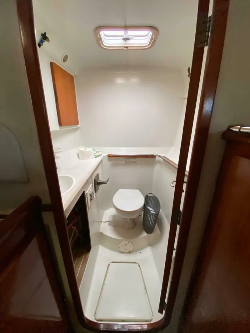 Slide: The Image of 1993 Privilege Boolean yacht bathroom with toilet, sink, and wooden accents. - 11