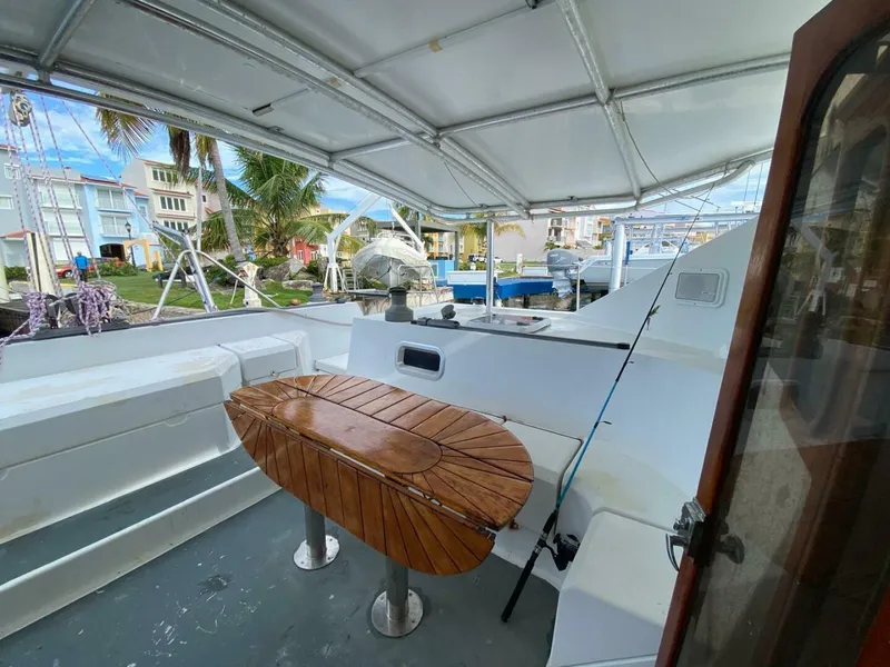 Slide: The Image of Covered deck of 1993 Privilege Boolean yacht with wooden table and marina view. - 7
