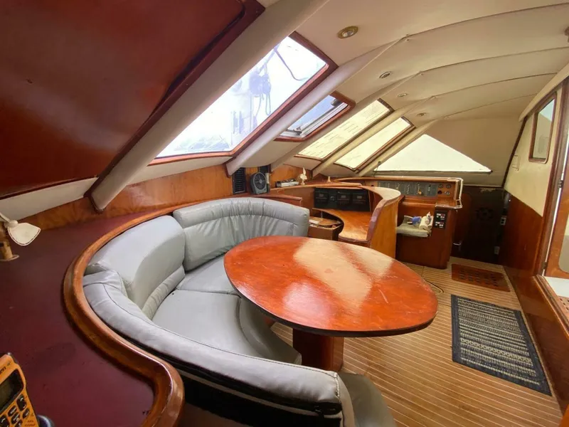 Slide: The Image of Luxurious 1993 Privilege Boolean yacht interior with curved seating and wooden table. - 8