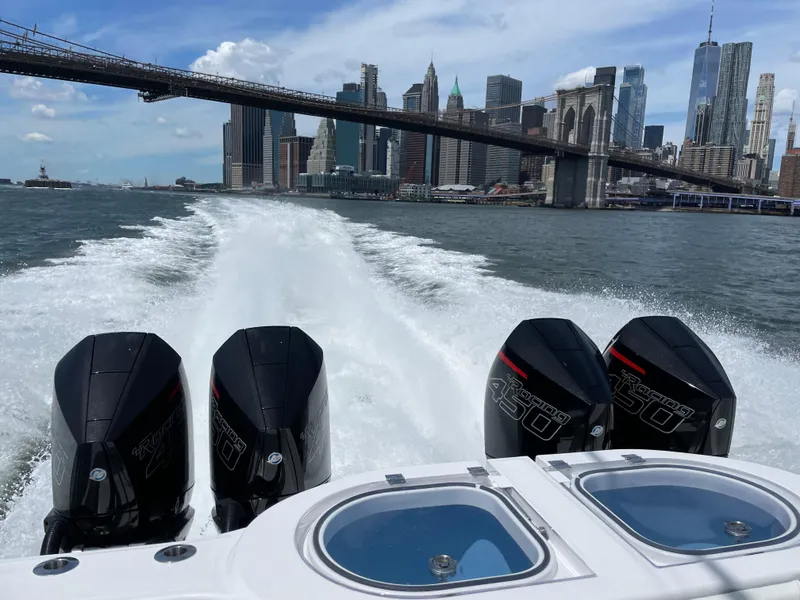 Slide: The Image of Invincible 40 Catamaran 2022 cruising near city skyline and bridge, powerful engines visible. - 1