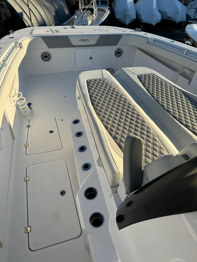 Slide: The Image of 2022 Invincible 40 Catamaran interior with diamond-stitched seating and multiple storage compartments. - 15