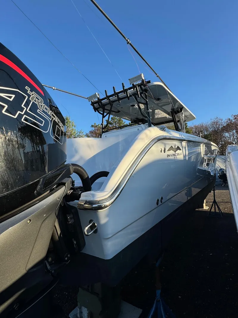 Slide: The Image of 2022 Invincible 40 Catamaran with powerful outboard engine, docked under clear blue sky. - 4