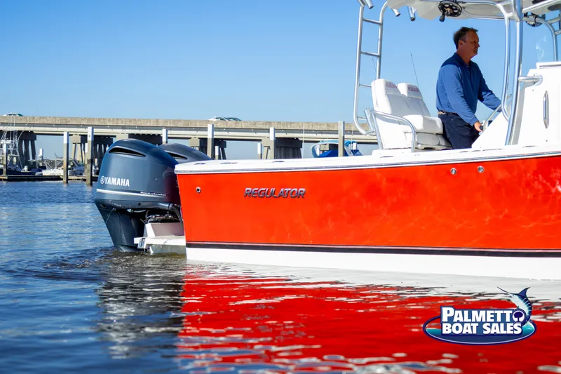 Slide: The Image of Red 2011 Regulator 28 boat with Yamaha engine on water near bridge. - 13