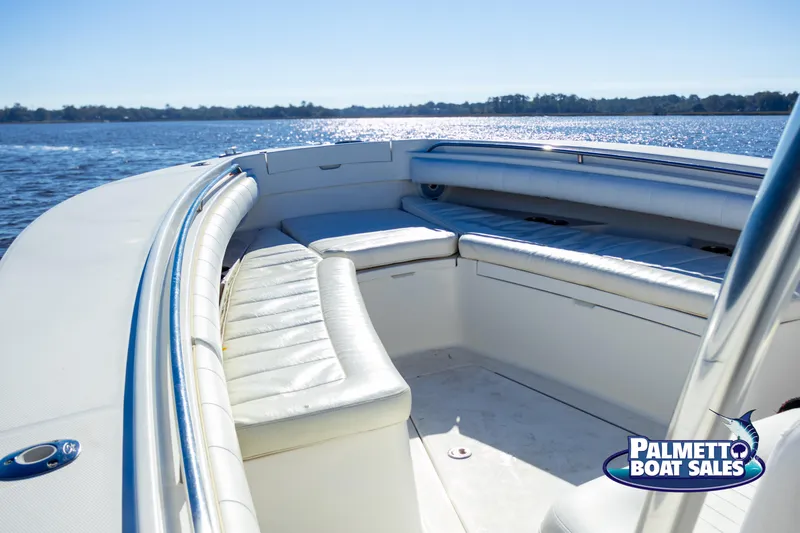 Slide: The Image of 2011 Regulator 28 boat interior with seating, on calm water, Palmetto Boat Sales logo. - 27