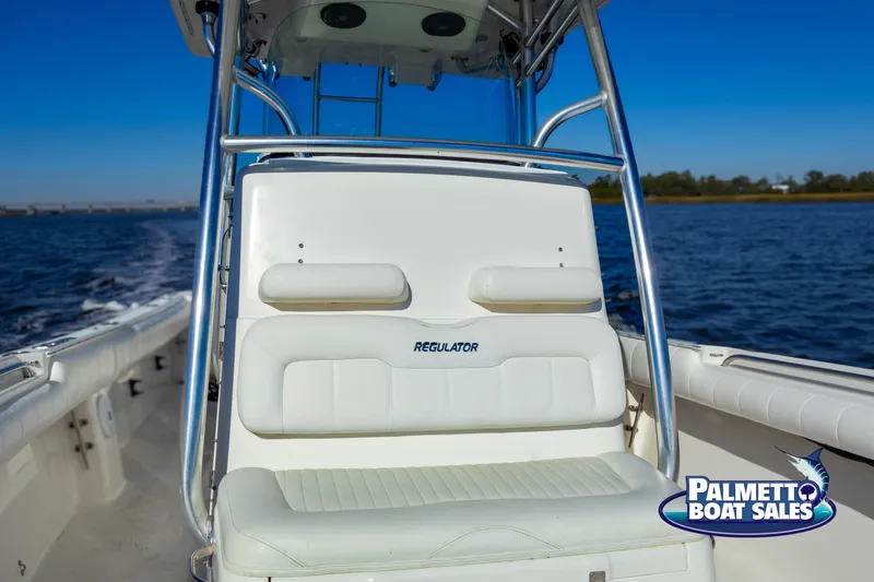 Slide: The Image of 2011 Regulator 28 boat on water, featuring white seating and Palmetto Boat Sales logo. - 30
