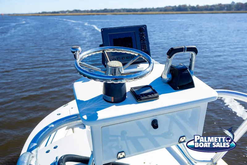 Slide: The Image of 2011 Regulator 28 boat console on open water, featuring steering wheel and navigation equipment. - 36