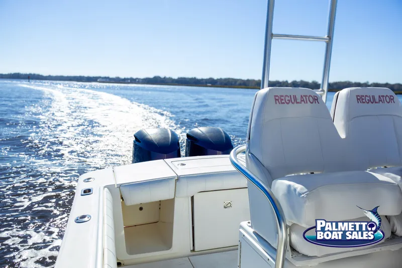 Slide: The Image of 2011 Regulator 28 boat cruising on open water, featuring dual engines and branded seating. - 39