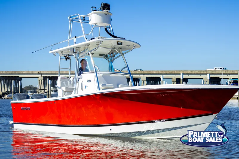 Slide: The Image of Red 2011 Regulator 28 boat on water near a bridge, Palmetto Boat Sales logo visible. - 8