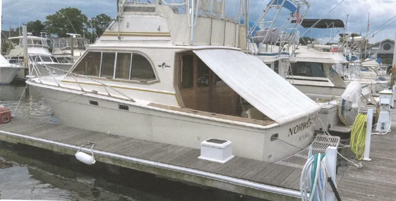 Slide: The Image of 1983 Egg Harbor 33 Convertible boat docked at a marina, featuring classic design and structure. - 0
