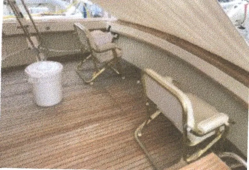 Slide: The Image of 1983 Egg Harbor 33 Convertible boat deck with chairs and wooden flooring. - 1