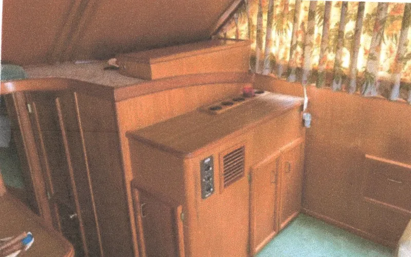 Slide: The Image of Interior of 1983 Egg Harbor 33 Convertible boat with wooden cabinetry and floral curtains. - 11