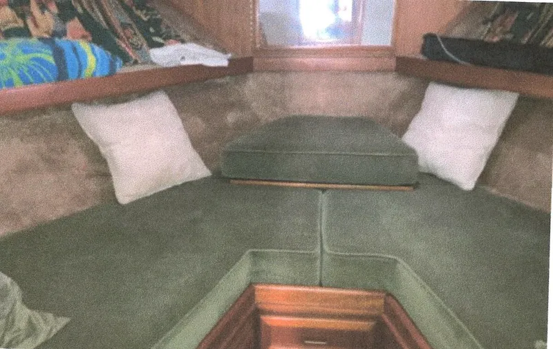 Slide: The Image of Interior cabin of a 1983 Egg Harbor 33 Convertible boat with green cushions and pillows. - 14