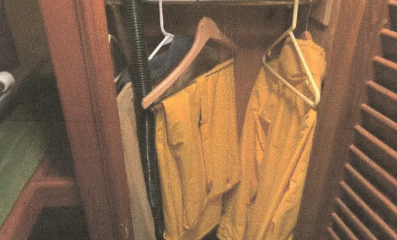 Slide: The Image of Yellow rain gear hanging in a wooden closet on a 1983 Egg Harbor 33 Convertible boat. - 16