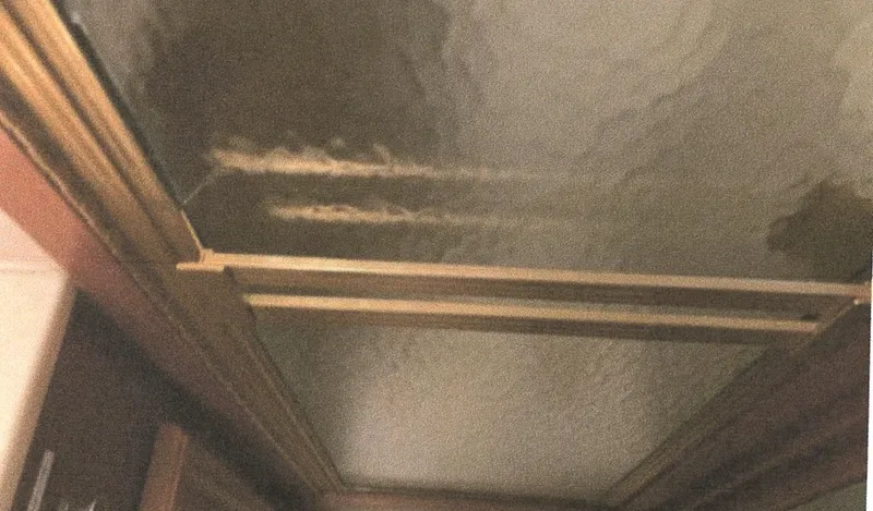 Slide: The Image of Ceiling view inside 1983 Egg Harbor 33 Convertible boat, showing wooden beams and water damage. - 19
